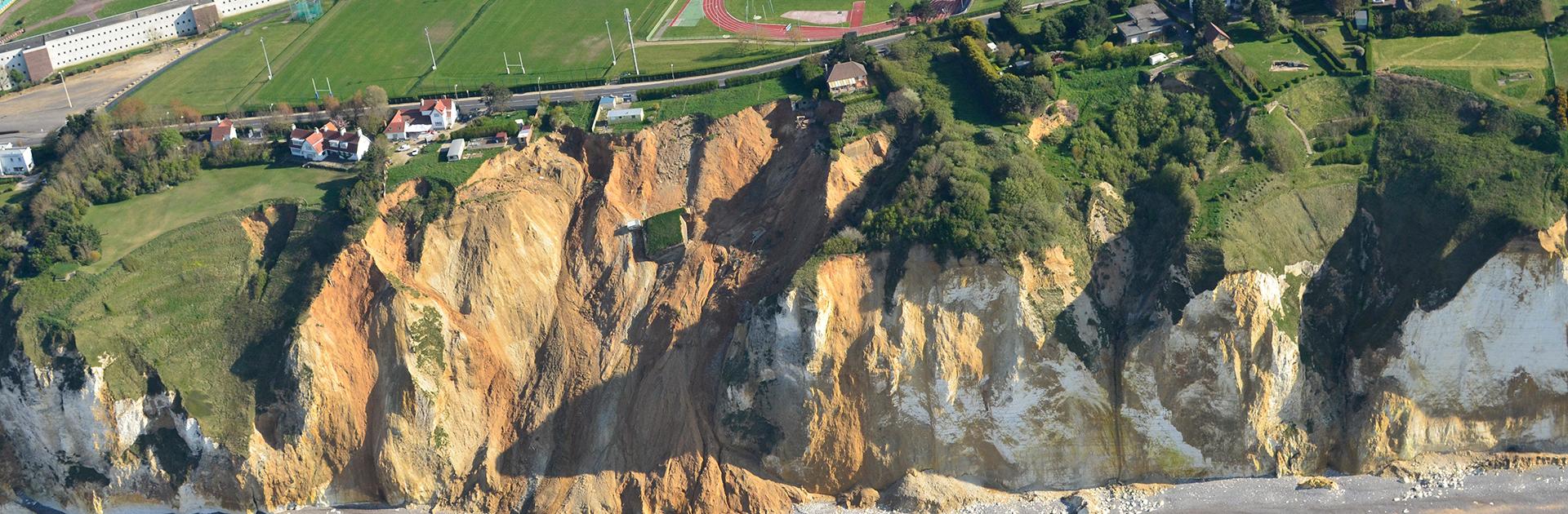 Effondrement lié à une poche de matériaux argilo-sableux au sein d’une falaise de craie entre Dieppe et Pourville menaçant une route, des habitations et un stade (Seine-Maritime, 2014).